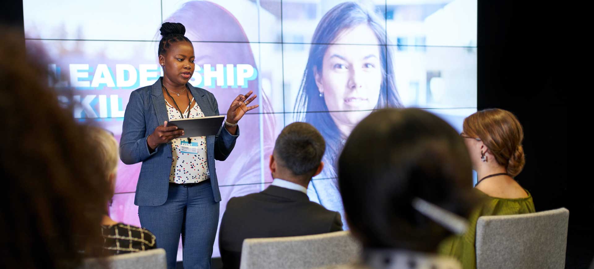 Woman speaking in front of a live and virtual audience