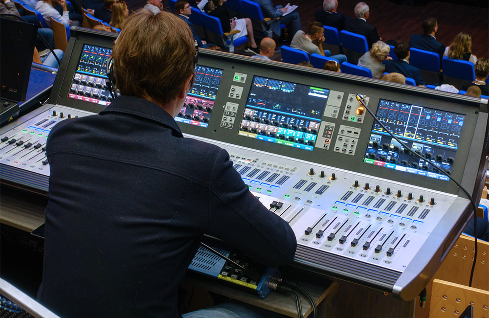 Man behind sound board for a blog about corporate audio visual event planning